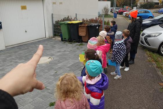 Kinder aus Haus 1 entdecken Mülltonnen in der Nachbarschaft